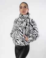 Mujer usando chamarra color blanco con rayas negras.