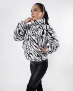 Mujer usando chamarra color blanco con rayas negras.