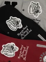 Chamarras beisboleras rojo, negro y gris con dibujo de tigre.